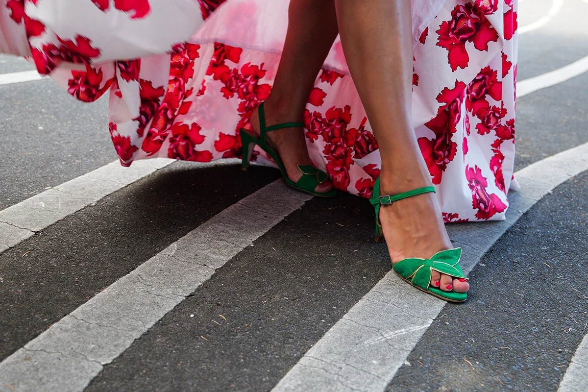 Close up of fashionable green open high heels having as background a fashionable dress and the black iconic lights of Den Sorte Plads in Copenhagen.