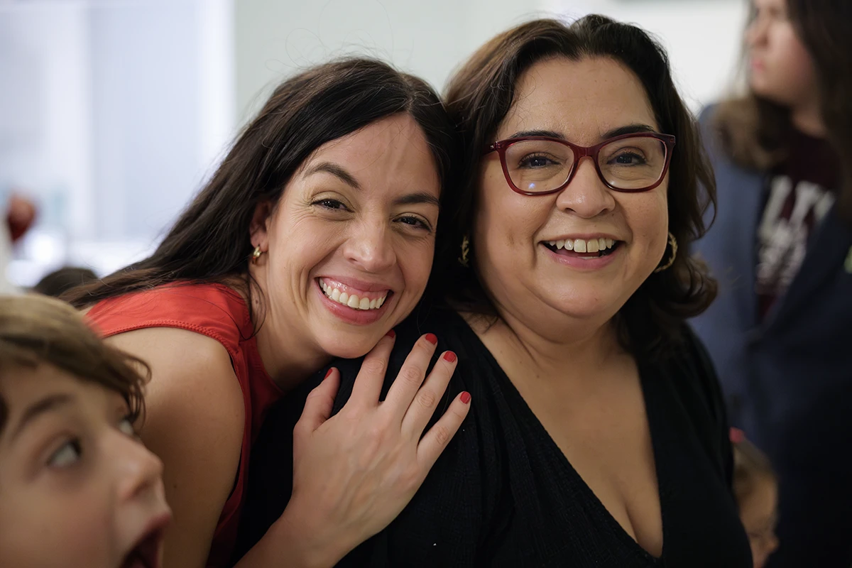 Birthday hug from the celebrant to a guest; their embrace captured mid-gesture, full of warmth and connection.