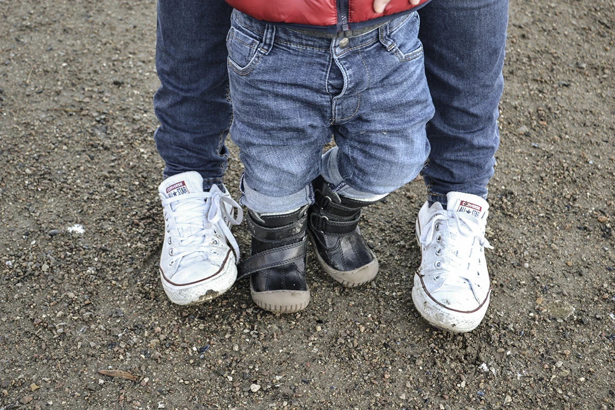 Close up of mom and baby's feet walking together.